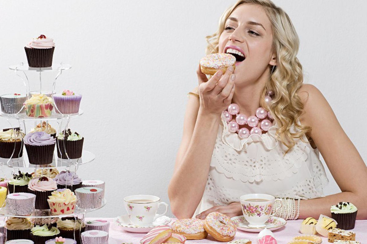 Una chica comiendo pasteles