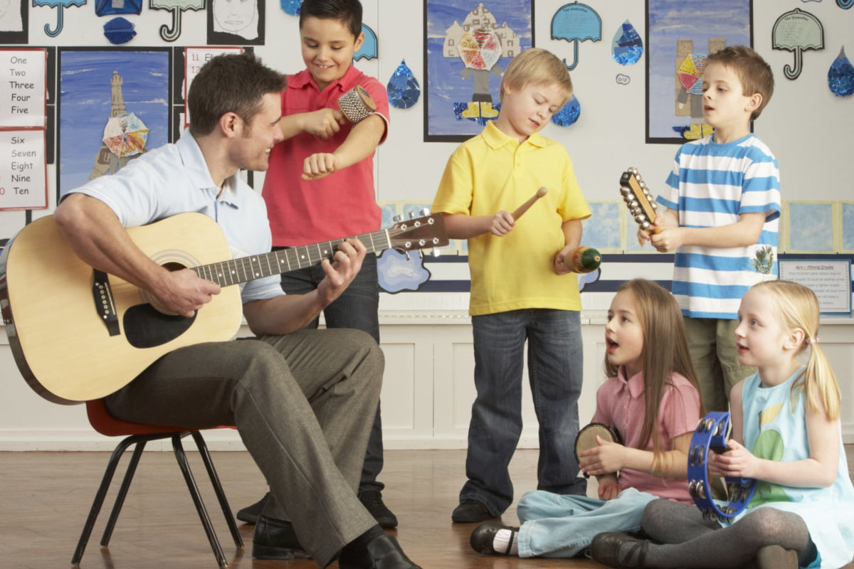 Un hombre y varios niños tocan instrumentos musicales