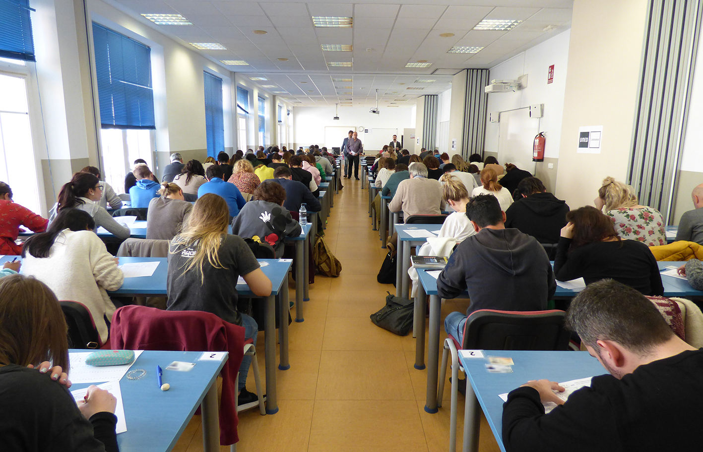 Universitarios en una sala haciendo un examen