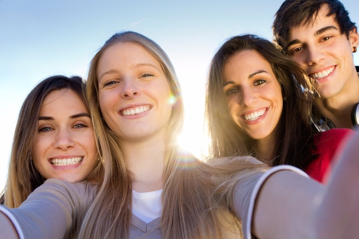 Un grupo de jóvenes sonríen haciéndose un selfie