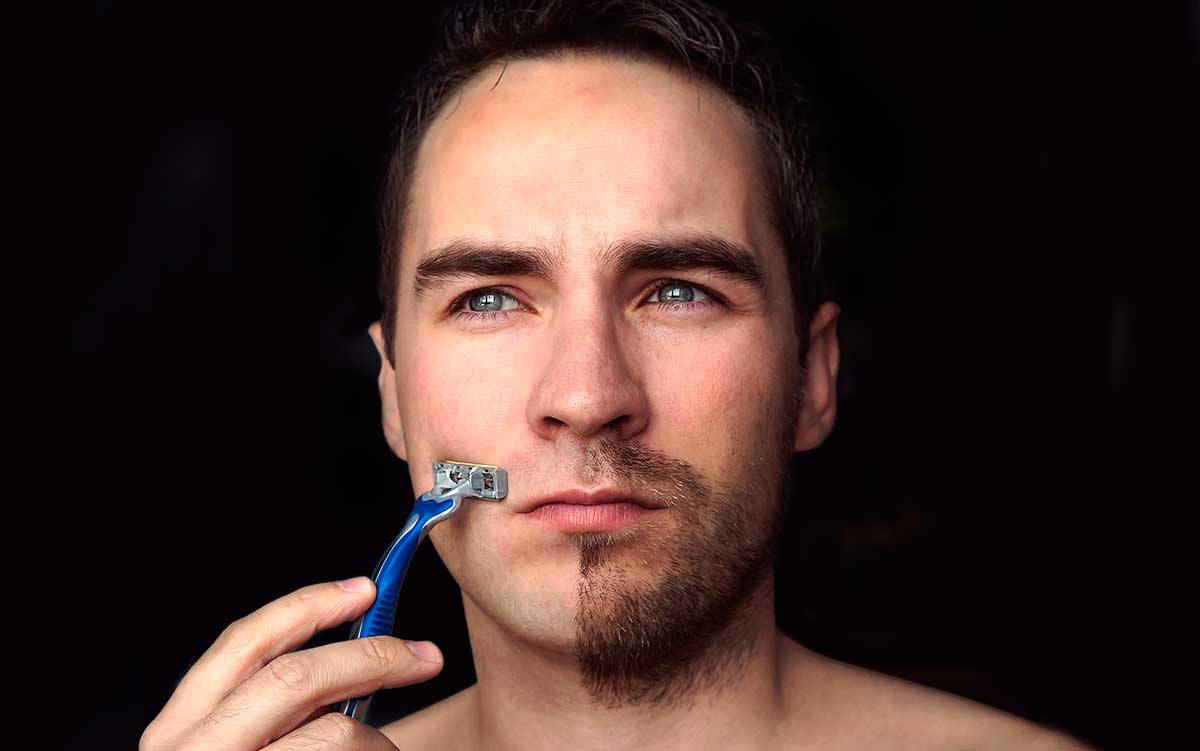 Un hombre se afeita sólo media barba