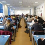 Universitarios en una sala haciendo un examen