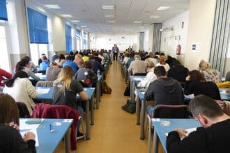 Universitarios en una sala haciendo un examen