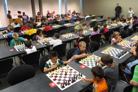Muchos niños participando en un torneo de ajedrez